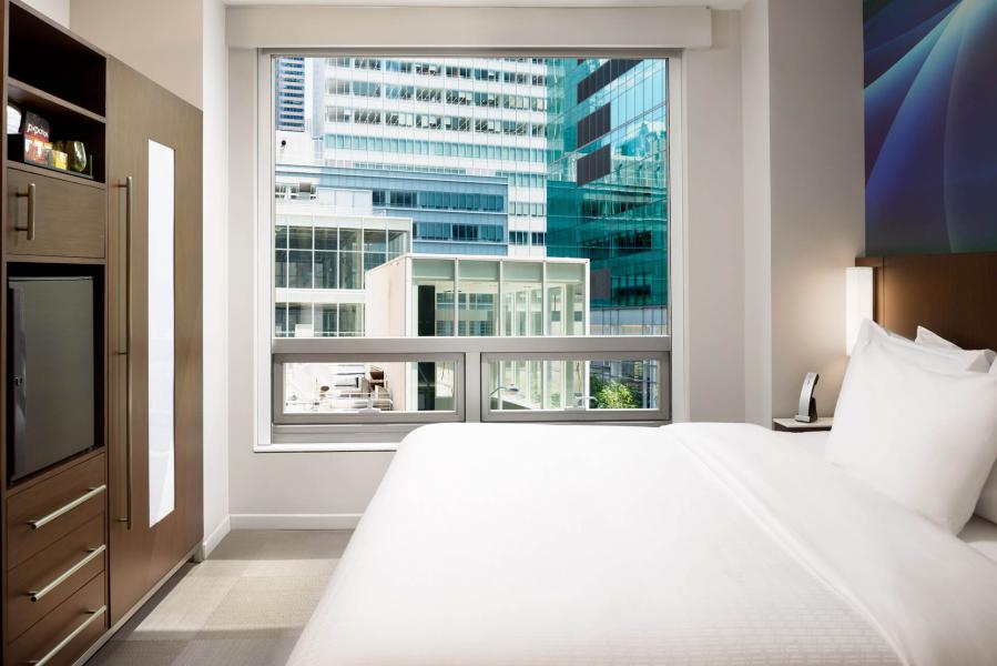bed next to a window with a city view