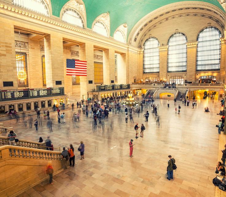 A Large Room With People In It With Grand Central Terminal In The Background