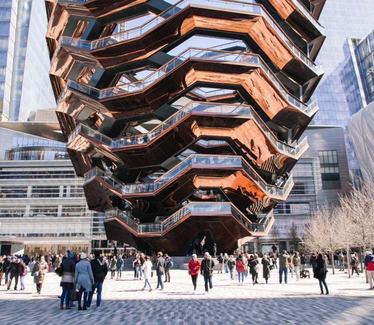 A Group Of People Walking Around A Building