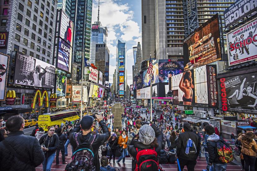 A Busy City Street With Times Square In The Background