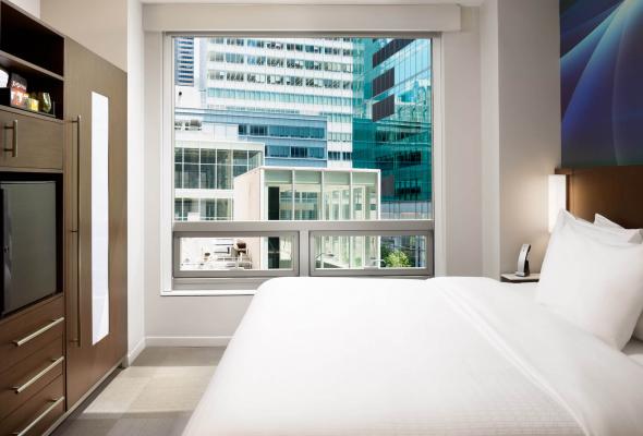 bed next to a window with a city view