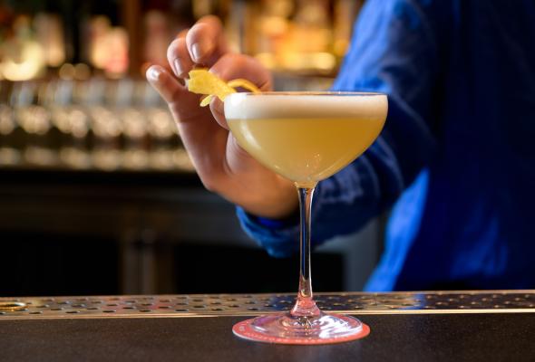 Cocktail being garnished by a bartender