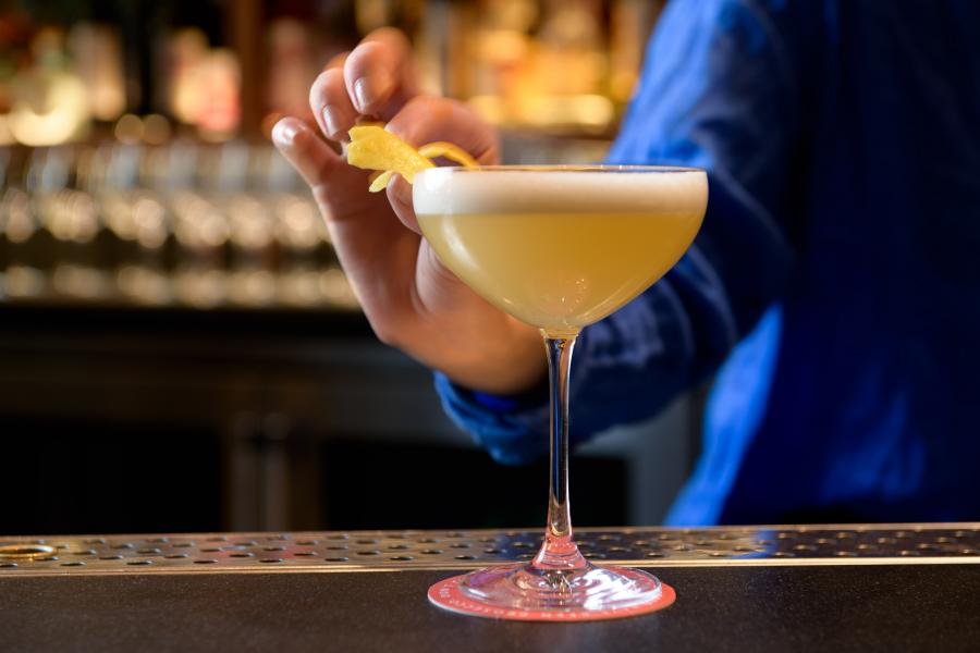 Cocktail being garnished by a bartender