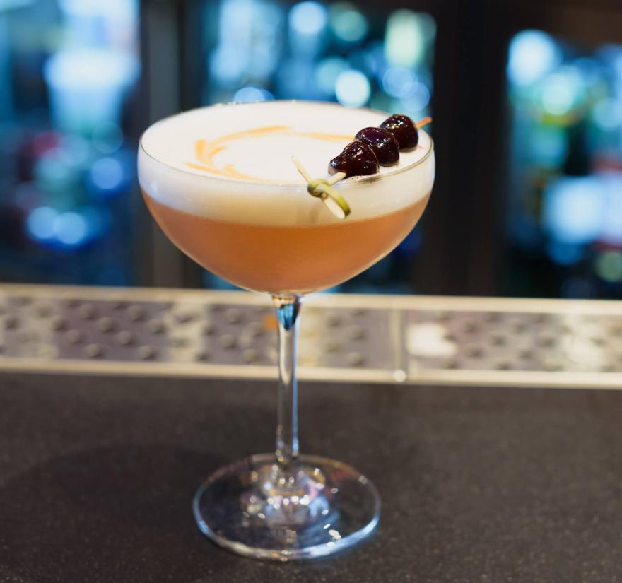 Close up of a cocktail with a cherry garnish