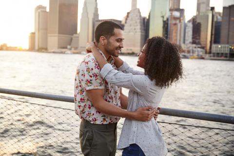 couple embracing with NYC skyline in background
