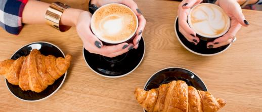 Top down view of the LUMA continental breakfast being served on a table with coffee.